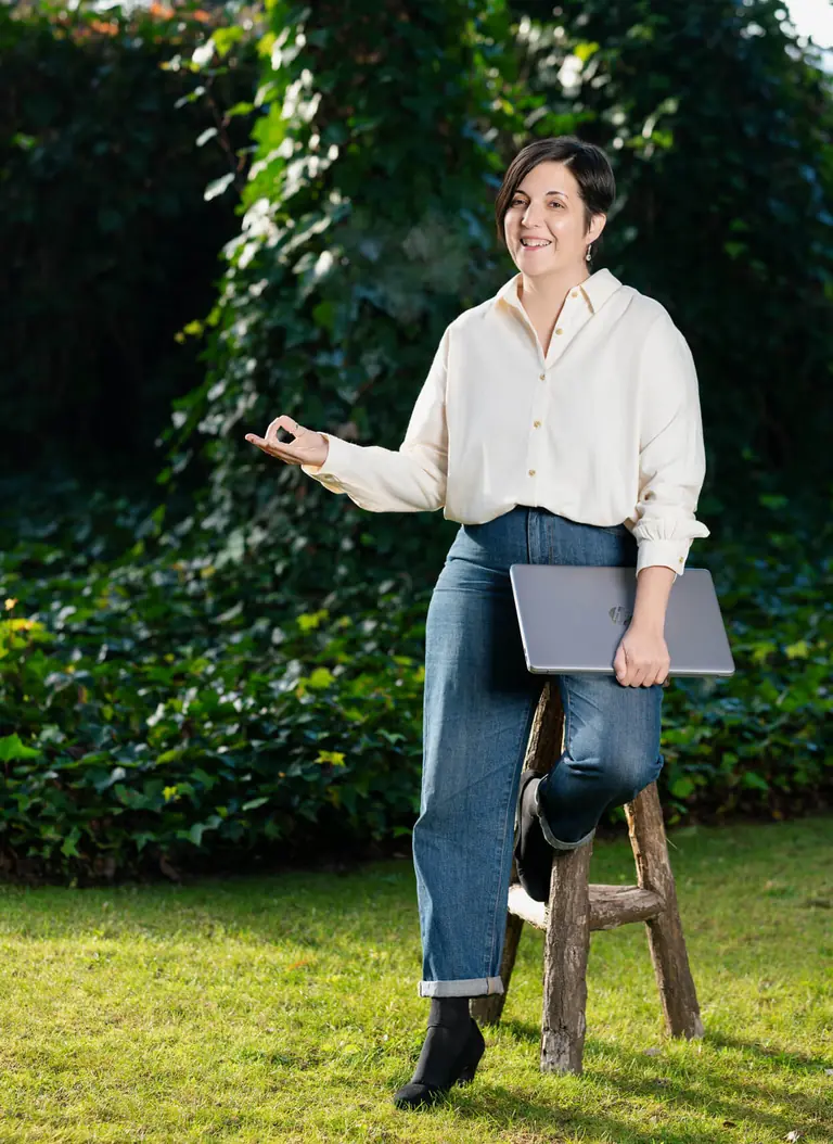 Laura Rabot de pie en el jardín con su portátil